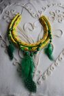 Yellow dreamcatcher with green guinea fowl feathers.